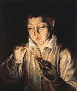 A Boy blowing on an Ember to light a candle